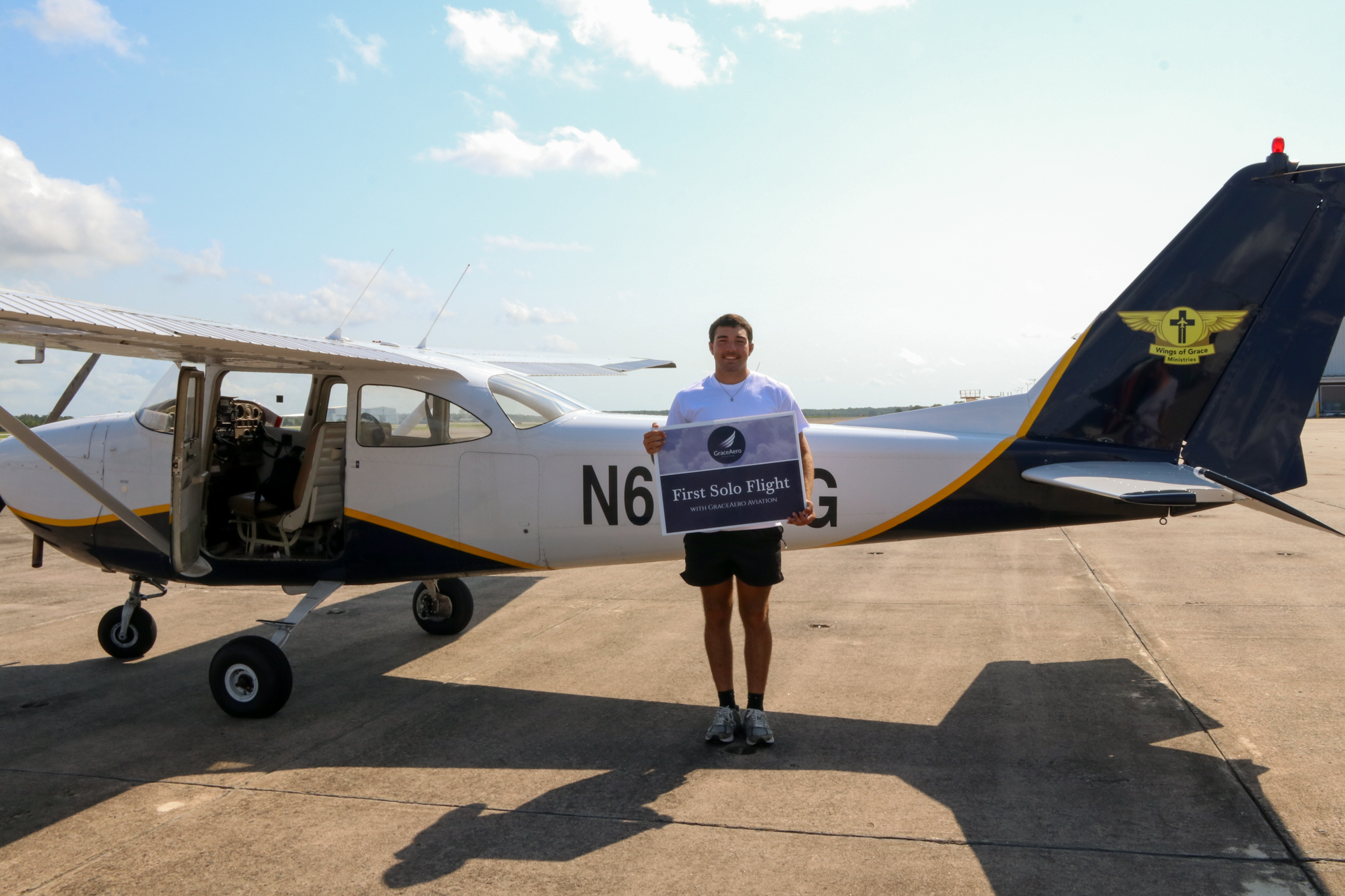 Wings of Grace aviation students gathered in front of a training aircraft
